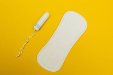 Hijyenik pedler ve tampon sarı bir arka plan üzerinde.