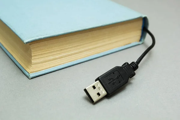 Boeken met een connector voor aansluiting op een computer op een grijze bac — Stockfoto