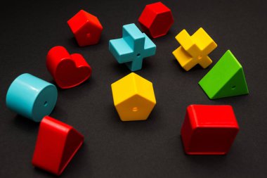 Hacimsel çok renkli oyuncak figürler bir siyah arka plan üzerinde çapraz