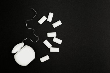 Diş ipi ve sakız siyah bir zemin üzerine.