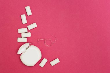 Sakız çiğneme ve diş ipi pembe bir arka plan üzerinde. Tex için alan