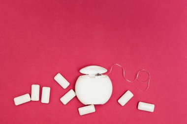 Diş ipi ve sakız yastıkları pembe bir arka plan üzerinde uzay fo