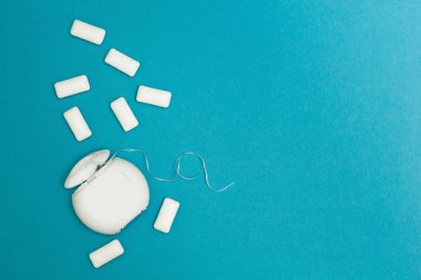 Sakız çiğneme ve diş ipi mavi bir arka plan üzerinde. Tex için alan