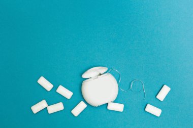 Sakız çiğneme ve diş ipi mavi bir arka plan üzerinde. Tex için alan