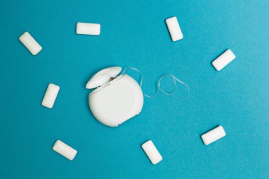 Sakız çiğneme ve diş ipi mavi bir arka plan üzerinde.