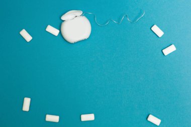 Sakız çiğneme ve diş ipi mavi bir arka plan üzerinde. Tex için alan