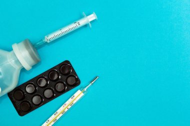 Şırınga, hap, mavi arka plan, te alan üzerinde termometre