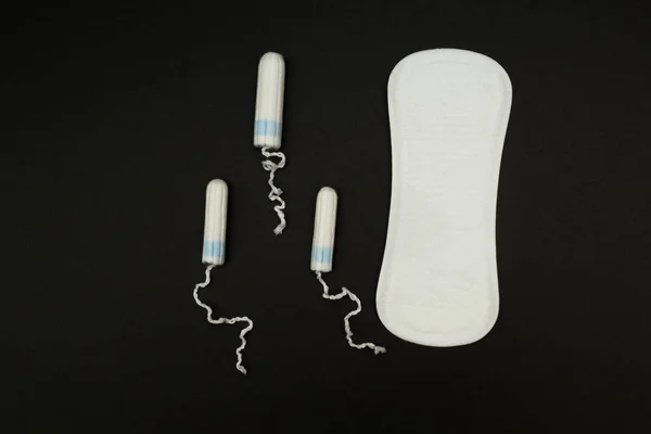 Sanitary pads and tampons on a black background. — Stock Photo, Image