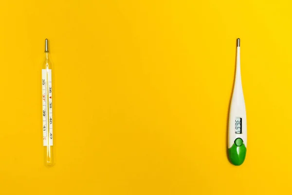Аналоговый и цифровой термометр на желтом фоне, со spac — стоковое фото