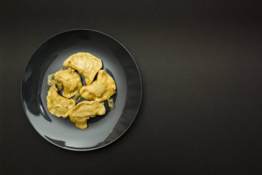 Siyah plaka börek siyah bir arka plan ile. Metni için bir yer.