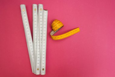 Cetvel katlama ve pembe bir arka plan kasette ölçme.