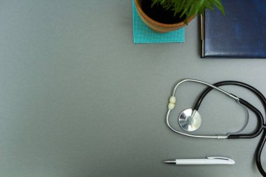 Doktorun işyeri. Kalem, stetoskop ve çiçek ile not etmek