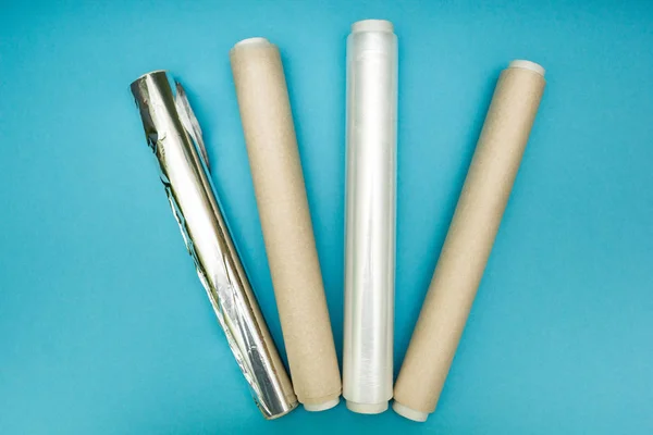 Envoltura de plástico, papel de aluminio y rollo de papel pergamino en azul — Foto de Stock