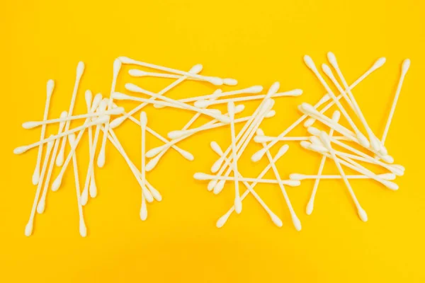 Cotton buds or cotton swabs on yellow background. — Stock Photo, Image