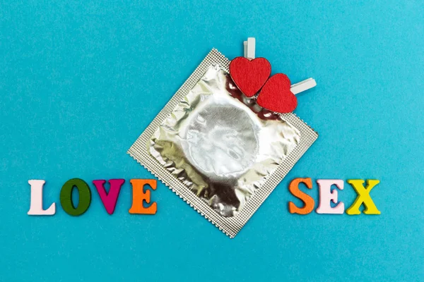 避孕套和红色的心在蓝色的背景, 题词 "爱 — 图库照片