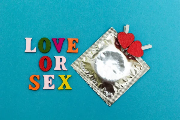 Kondom og røde hjerter på en blå baggrund, indskriften "lov - Stock-foto