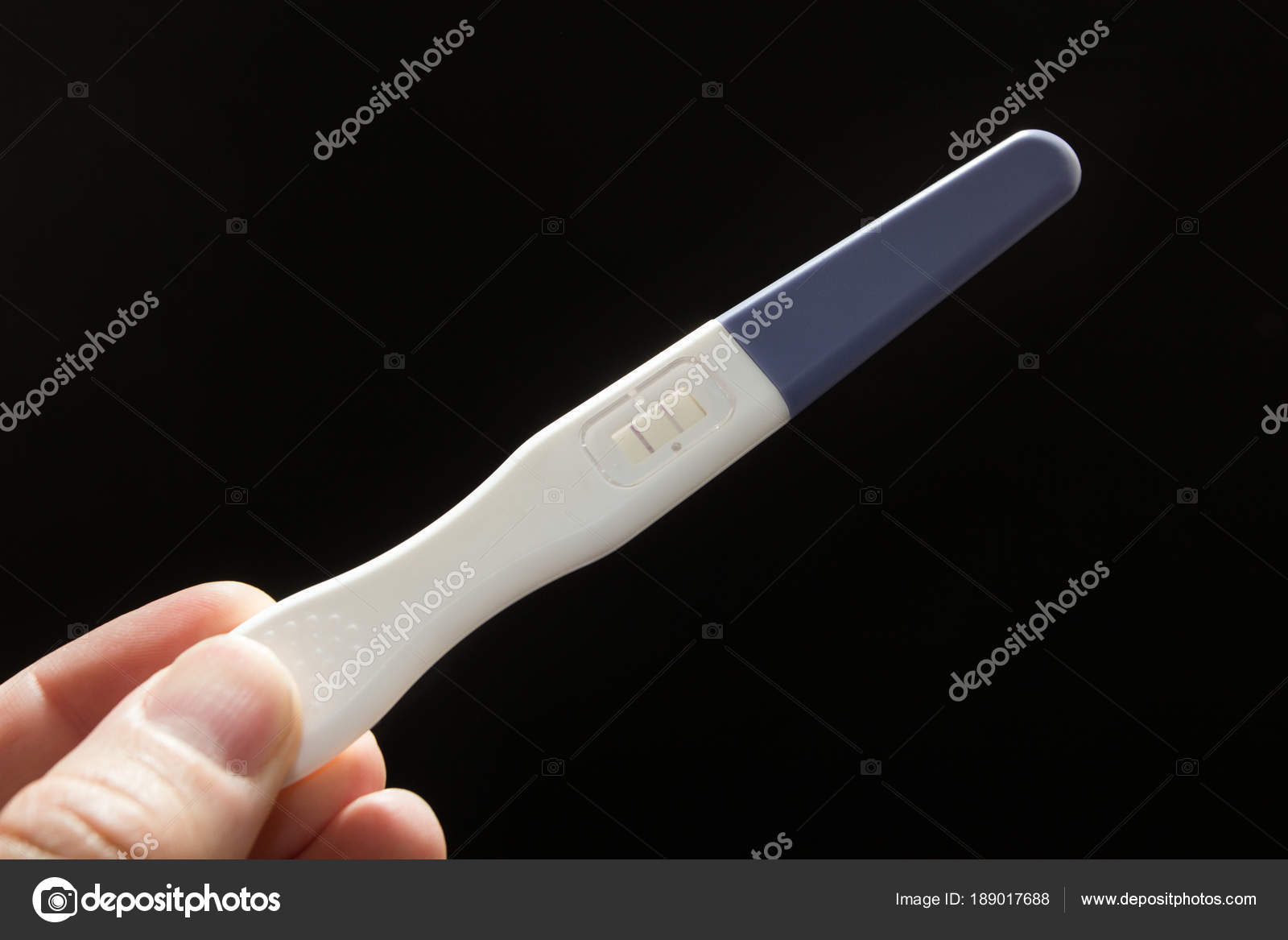 El blanco es una prueba de embarazo positiva en un fondo negro en una mano masculina Foto de stock 189017688 LIIMIT