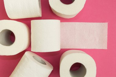 Pembe bir arka plan üzerinde beyaz tuvalet kağıdı rulo.