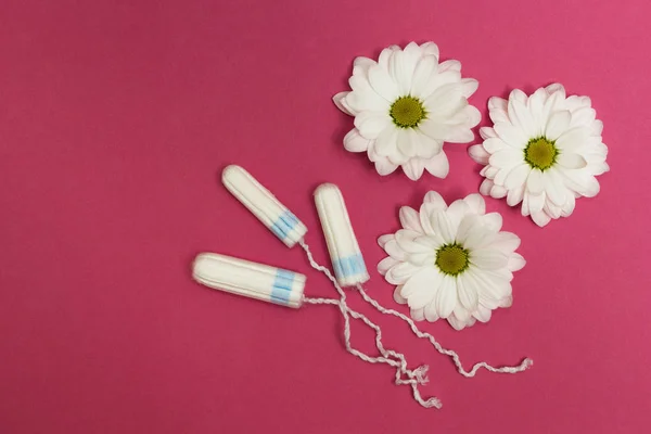 Tres tampones sobre fondo rosa con flores blancas . —  Fotos de Stock