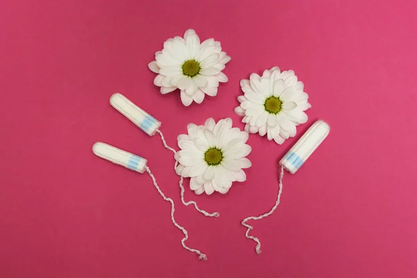 Tampones sobre fondo rosa con flores blancas . —  Fotos de Stock