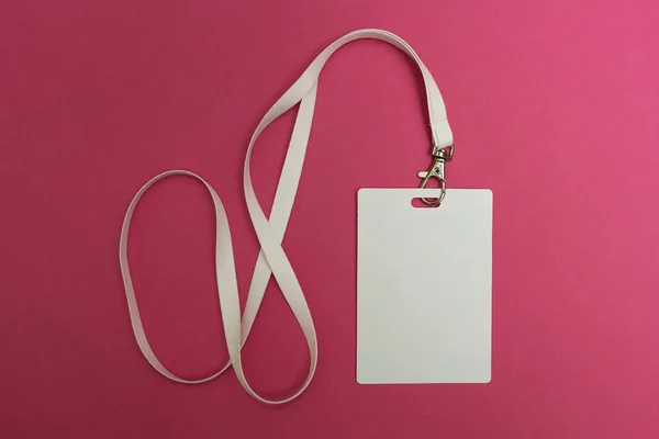 Üres azonosító kártyát az elszigetelt rózsaszín háttér, fehér nyakpánt. — Stock Fotó