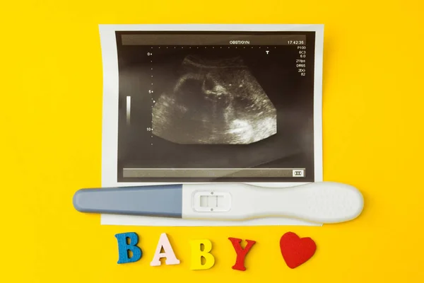 超声图像与阳性妊娠试验及 "婴儿" 一词". — 图库照片