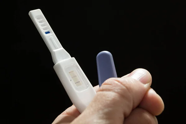 A man found a positive pregnancy test, against a black background. — Stock Photo, Image