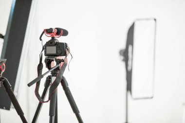 Kavram röportaj, Studio beyaz zemin üzerinde bir mikrofon ile bir tripod üzerinde dijital fotoğraf makinesi.