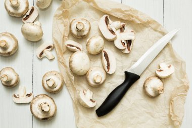 Bütün ve kesme organik mantar ve beyaz ahşap zemin üzerinde bıçak.