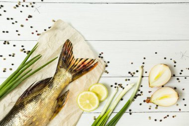 Beyaz ahşap bir masa üzerinde Aromatik baharatlar ile lezzetli taze balık. Metin, en iyi görünüm için yer.