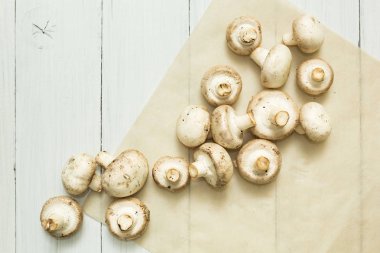 Taze mantar petrol beyaz ahşap zemin üzerinde.