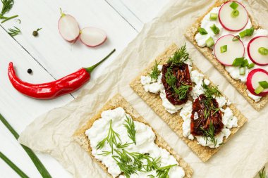 Beyaz ahşap zemin üzerinde kağıt üzerinde keçi peyniri rustik bir kahvaltı. Çiftçinin taze ürünler.