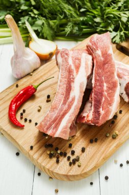 Çiğ domuz kaburga yağ sebze ve biber kesme tahtası ile katmanlarla.