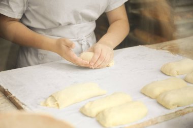 Aşçının elleri hamuru hafifçe yoğurur. Küçük aile pastanesi.