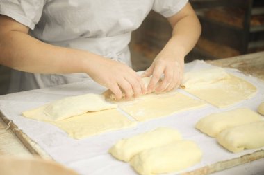 Kadınların elleri çiğ hamurdan turtalar hazırlıyor..