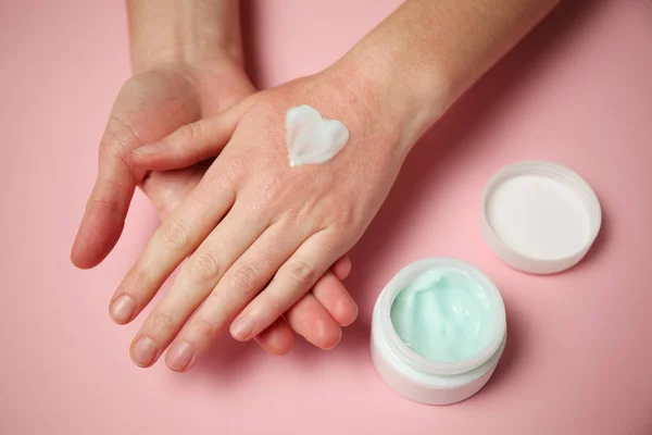 Las manos femeninas aplican crema hidratante a la piel. Irritación y alturas —  Fotos de Stock
