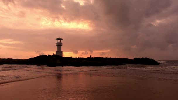 Phare avec vagues au coucher du soleil . — Video