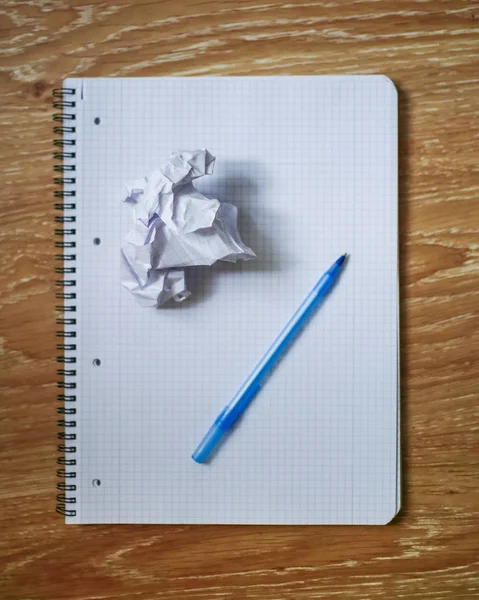 Buruşuk Kağıt topu, kalem ve defter masada