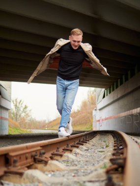 Sonbahar havası, yağmurluk giymiş genç adam yeraltında, sokak tarzı..