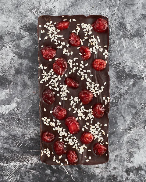 Handmade chocolate bar with cherry and sesame filling.