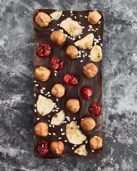 Шоколад ручной работы с вишней, бананами, кунжутом и орехами . — стоковое фото
