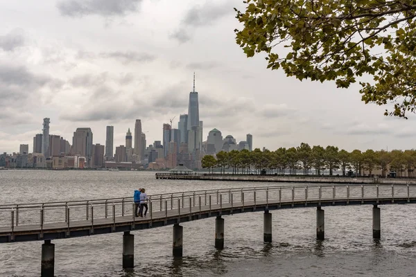 Pareja en el paseo marítimo con NY City Skyline en segundo plano — Foto de Stock