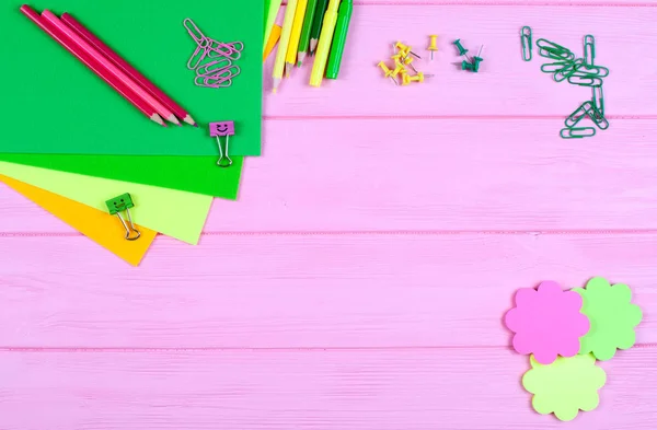 Lápices compañeros y verdes, rotuladores, papel, clips de papel, clavos de papelería, fieltro y sonrisas sobre fondo de madera rosa —  Fotos de Stock