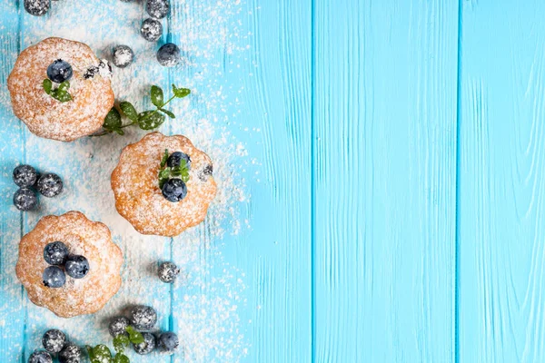 Böğürtlenli kek. Yaban mersini, taze meyveler, mavi ahşap zemin üzerine nane, toz şeker ile ev yapımı fırında kekim. Üstten Görünüm.