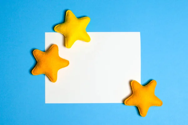 Basteln Sie gelbe Sterne am blauen Himmel mit Rahmen, Copyspace. Handgemachtes Filzspielzeug. abstrakter Himmel. — Stockfoto