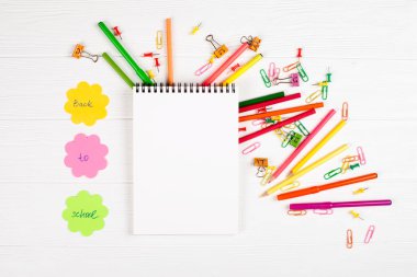 Beyaz ahşap arka plan üzerinde renkli kalem ve keçeli kalemler, renk notepaper, ataç, ileti örneği çivi