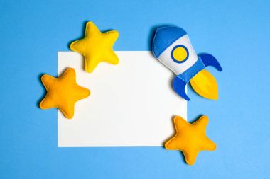 Roket çıkartıyor. El yapımı keçe oyuncak. Uzay gemisi Sundown arka plan üzerinde sarı yıldız.