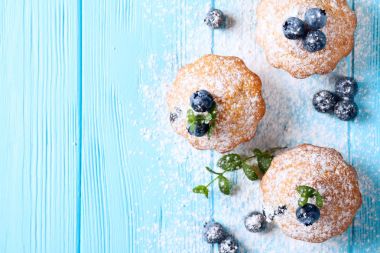 Yaban mersini, taze meyveler, mavi ahşap zemin üzerine nane, toz şeker ile ev yapımı Fırında kek. Üstten Görünüm.