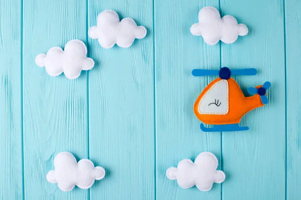 Helicóptero artesanal naranja y nubes sobre fondo de madera azul con copyspace. Juguetes hechos a mano. Espacio vacío para el texto. Vista superior . —  Fotos de Stock