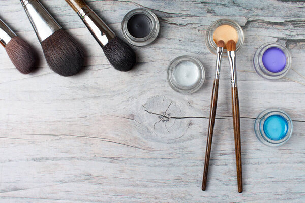Collection of make up products on wooden background with copyspace